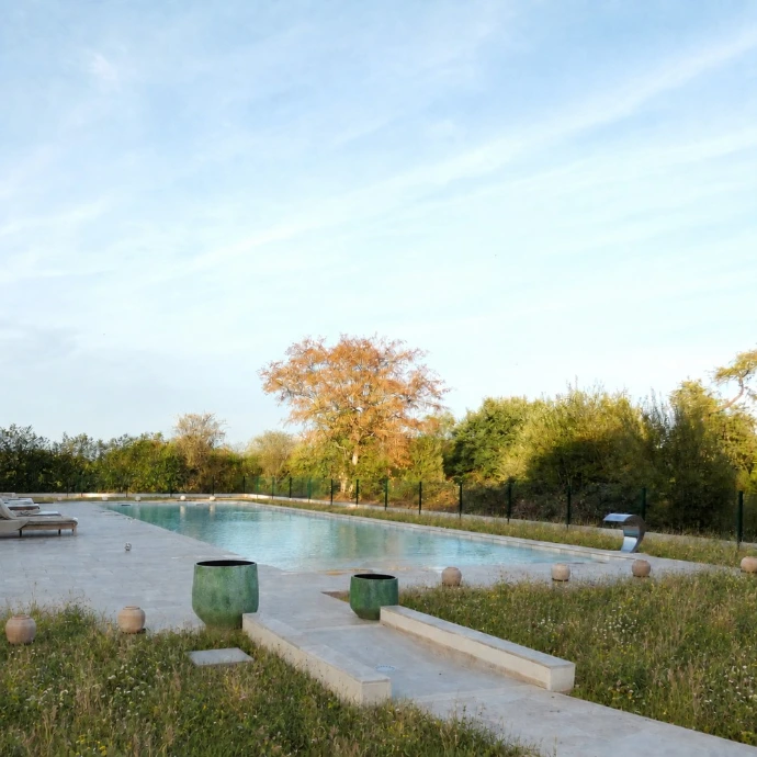 Piscine entourée de prairie fleurie au Grand Jardin, à l’automne